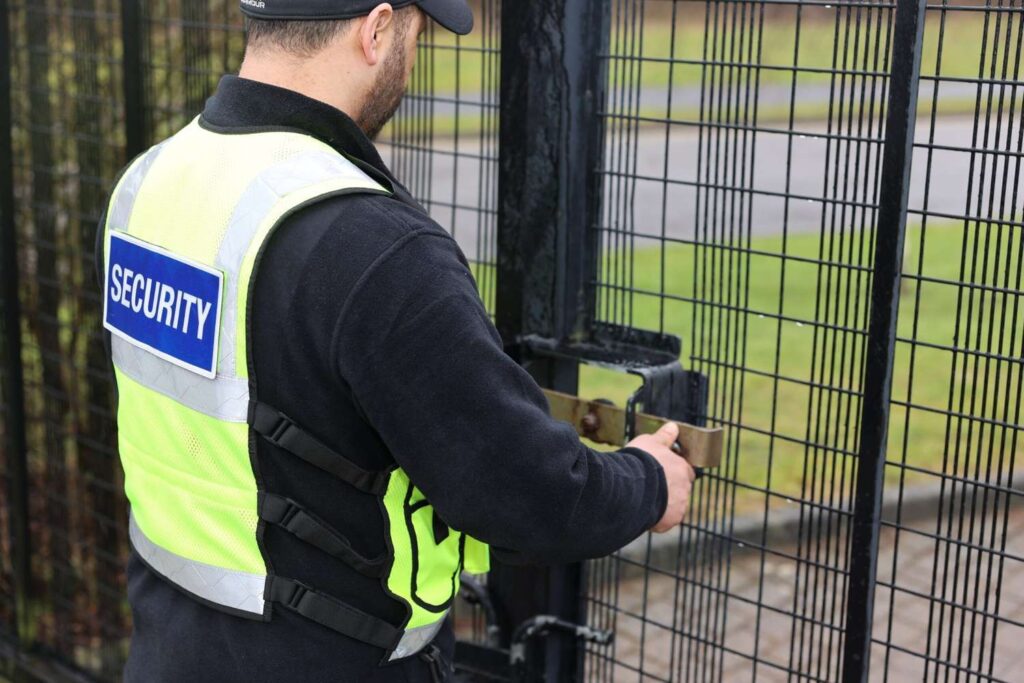 SIA licensed security officer unlocking a commercial building entrance in the early morning, ensuring the premises are safe for staff arrival.