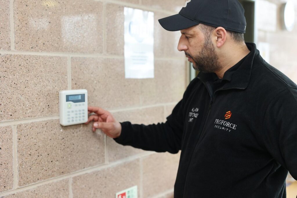 Professional security officer arriving at a commercial property at night to respond to an activated alarm system and investigate potential security threats.